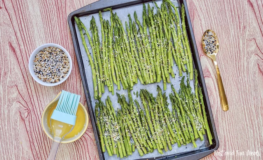 Brushing the sheet pan asparagus with butter. 