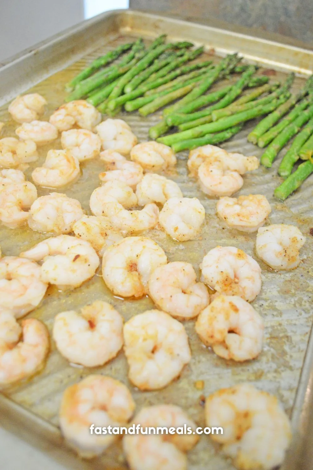 shrimp and asparagus on a baking sheet