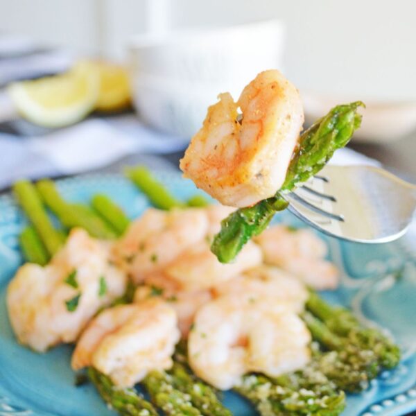 shrimp and asparagus being held up by a fork