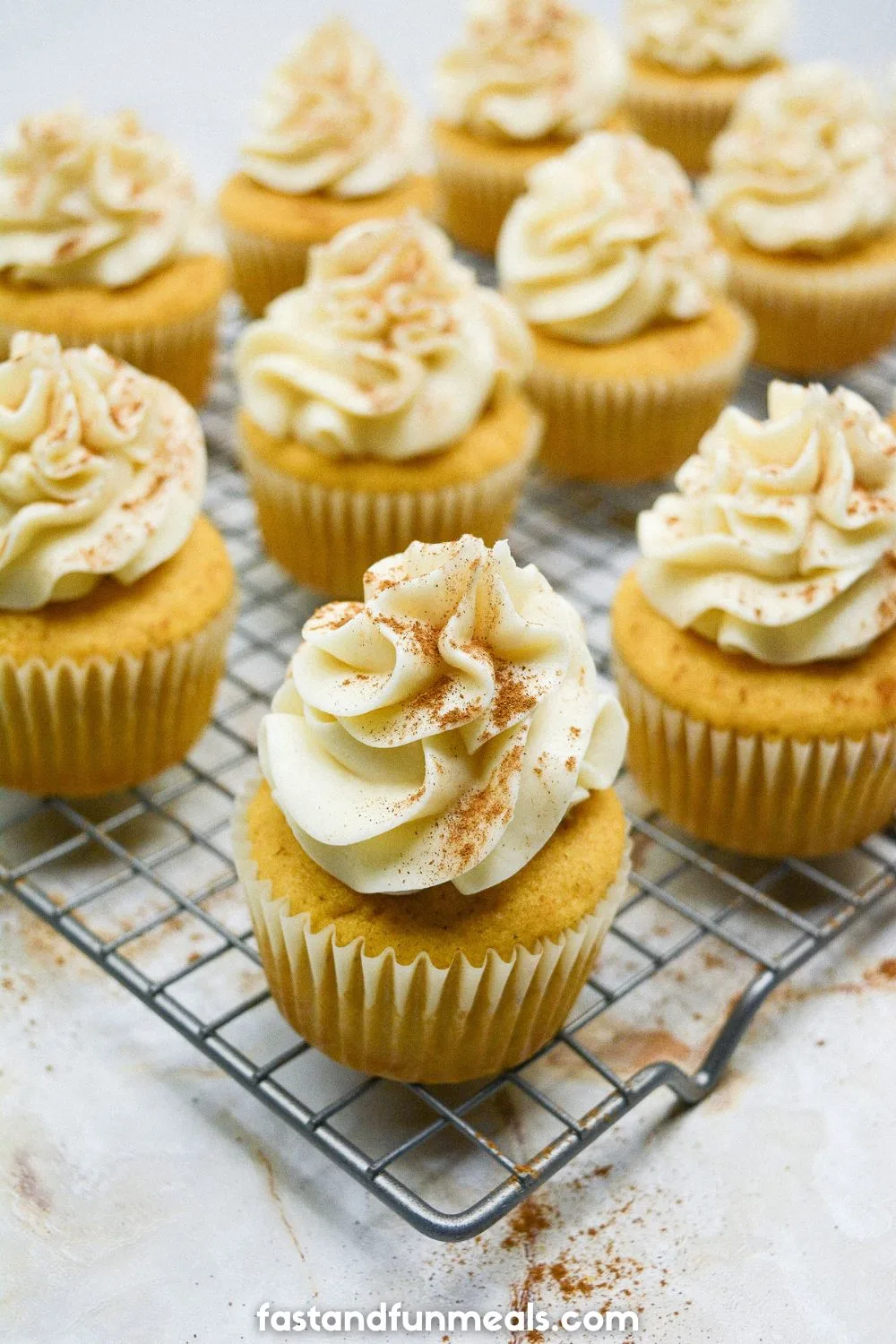 Pumpkin Cupcakes with Cream Cheese Frosting on a cooling rack